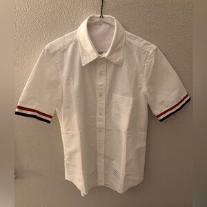 Thom Browne white shirt with stripes cuffs.